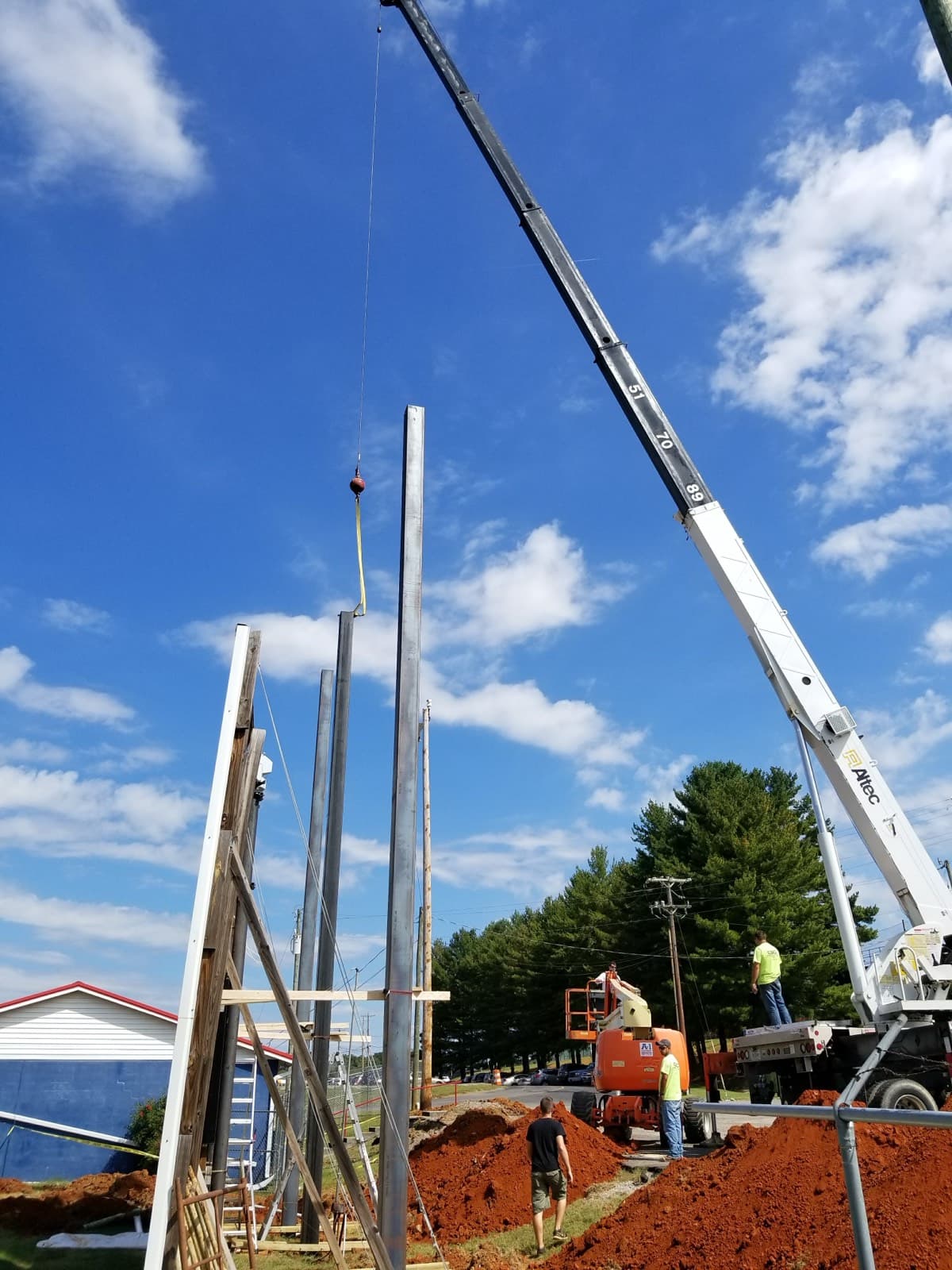 A Major Display crew setting scoreboard support structure on site with a crane